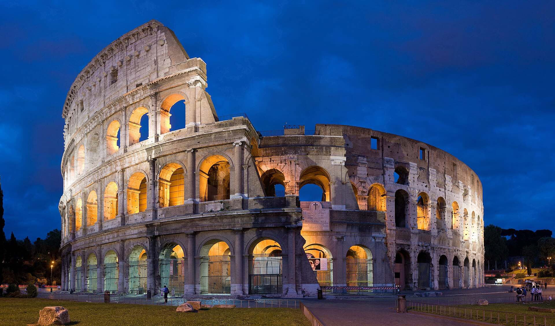 The Colosseum lit up against a deep blue evening sky