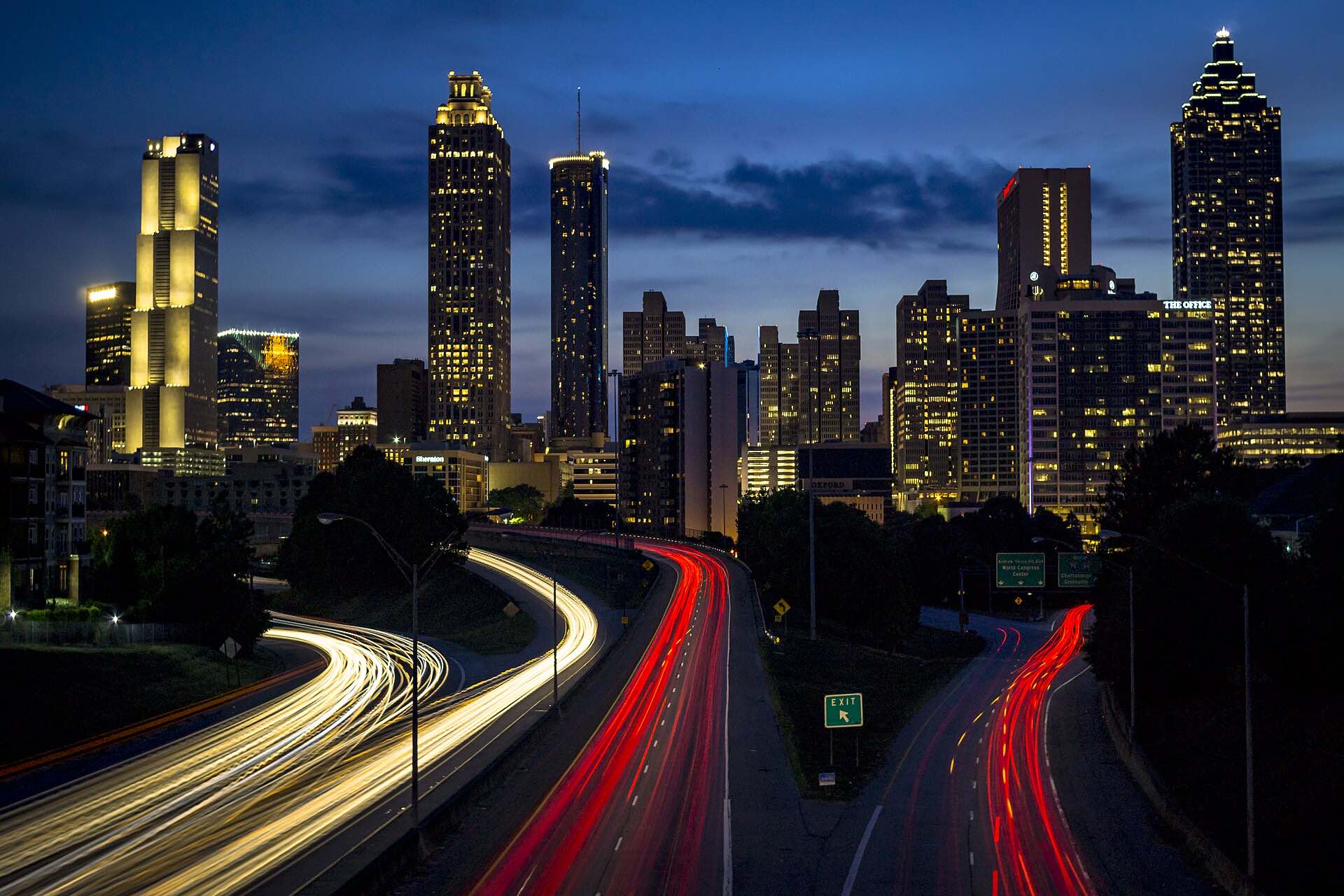 The Atlanta skyline at night above streaks of highway lights