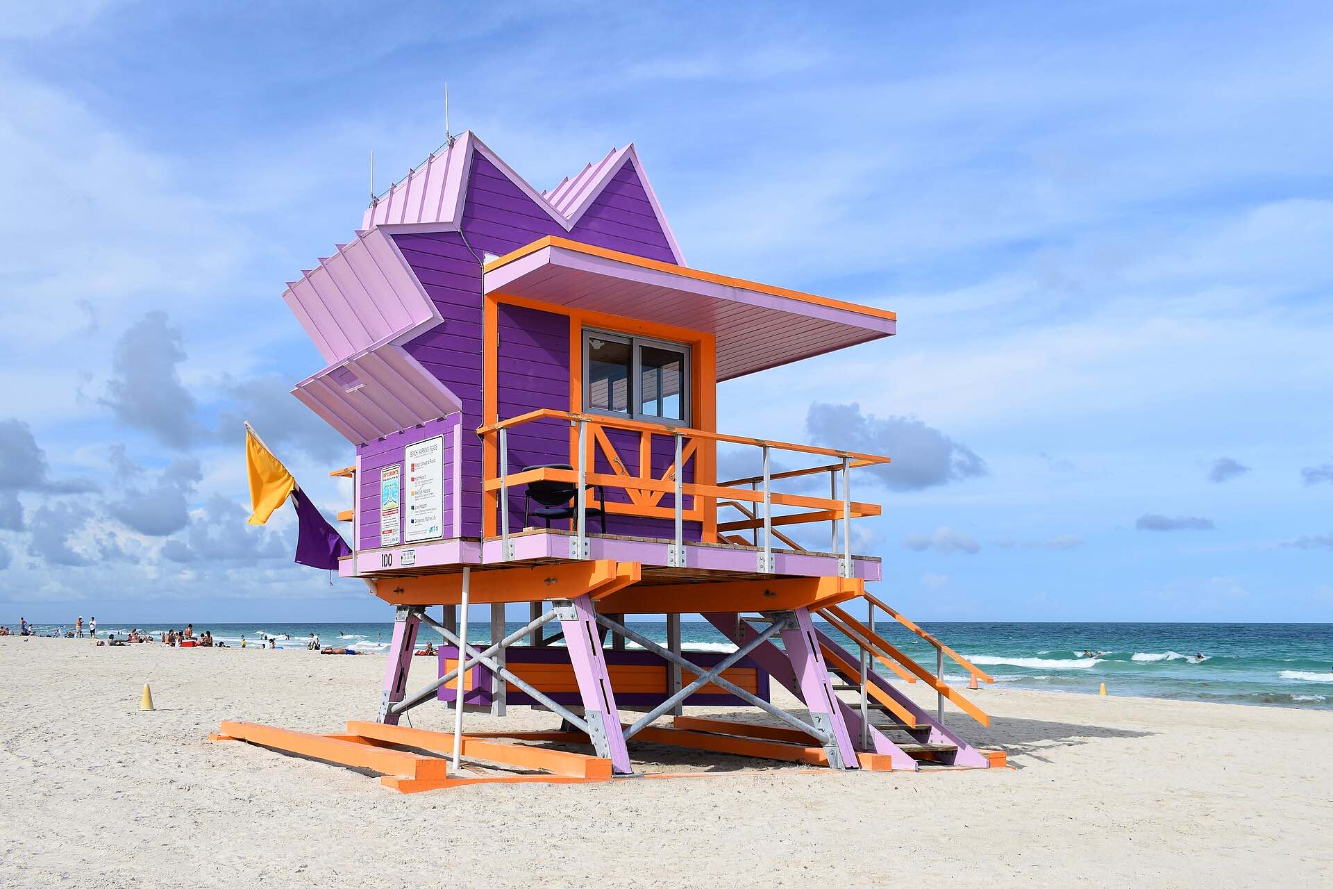 A purple and orange lifeguard tower on the sand at Miami Beach