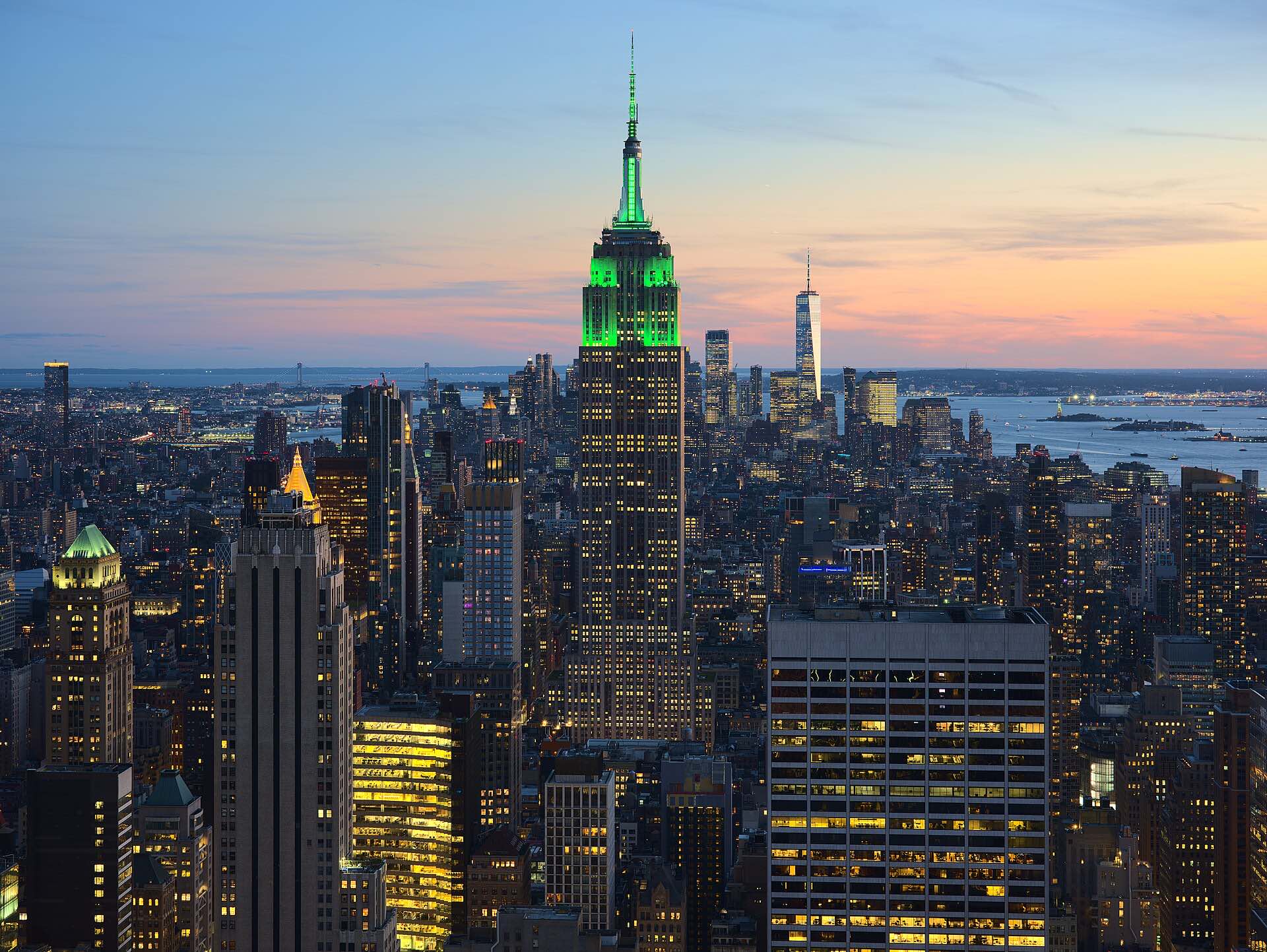 The Manhattan skyline at sunset with the Empire State Building lit in green